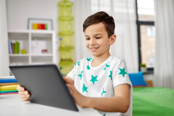 Menino estudante com tablet pc e notebook em casa — Fotografia de Stock