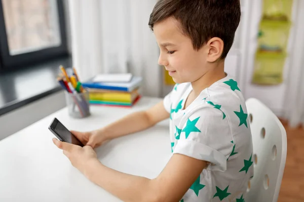 Menino feliz com smartphone em casa — Fotografia de Stock