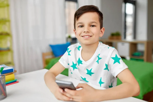 Menino feliz com smartphone em casa — Fotografia de Stock