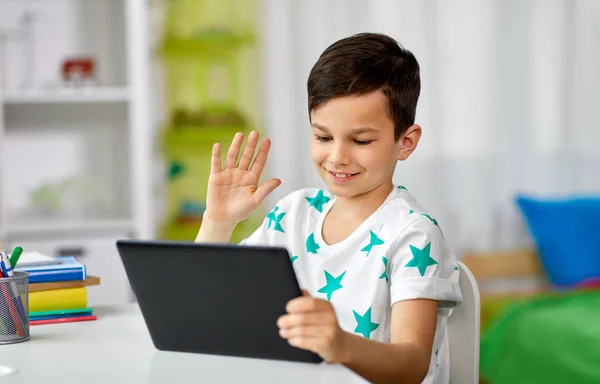 Chico con la computadora de la tableta que tiene video chat en casa —  Fotos de Stock