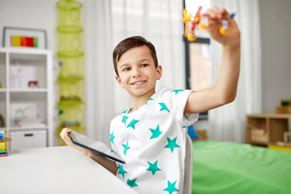 Junge mit Tablet-Computer und Spielzeugflugzeug zu Hause — Stockfoto