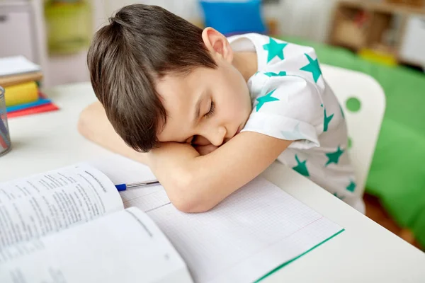 Yorgun öğrenci çocuk evde masaya yatıyor — Stok fotoğraf