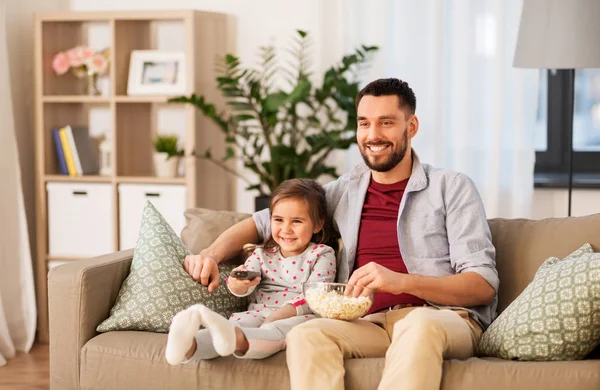 Lycklig far och dotter titta på tv hemma — Stockfoto