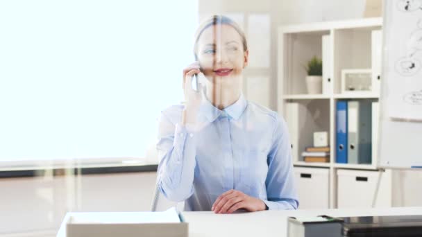 通信和人的概念 快乐的女商人打电话在智能手机在办公室 射穿玻璃 — 图库视频影像