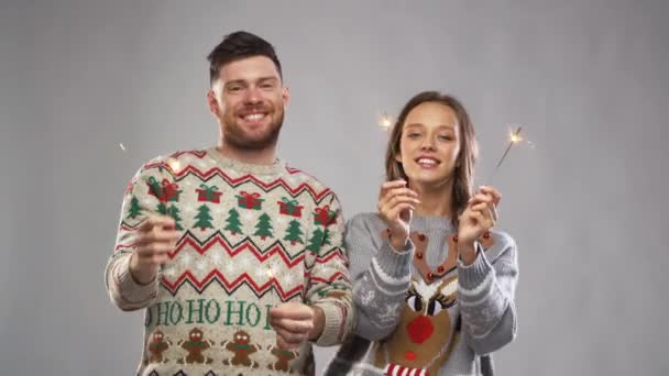 お祝い 楽しい 休日コンセプト 幸せなカップルを着て花火クリスマス パーティーでダンスでセーターを編んでください — ストック動画
