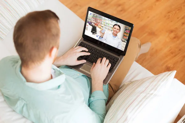 Man ha videosamtal med apotekspersonal på laptop — Stockfoto