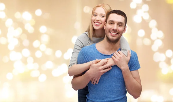 Χαμογελώντας ζευγάρι αγκαλιάζει πάνω από τα γιορτινά φώτα — Φωτογραφία Αρχείου