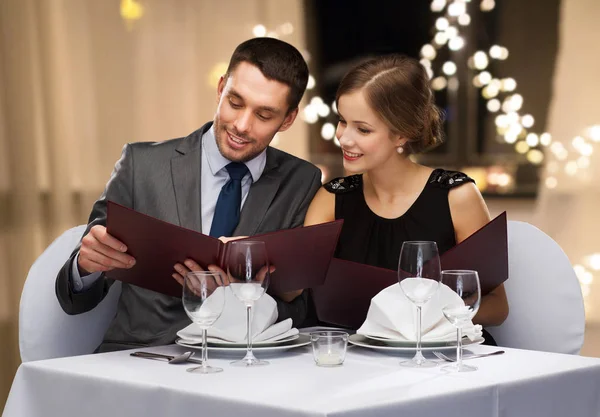 Paar mit Menüs im Restaurant — Stockfoto