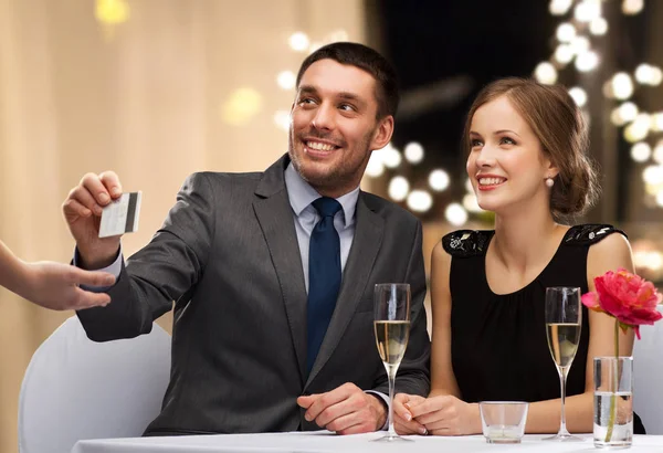 Happy couple at restaurant paying by credit card — Stock Photo, Image