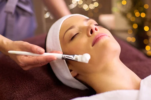 Esteticista aplicando mascarilla facial a mujer en spa — Foto de Stock