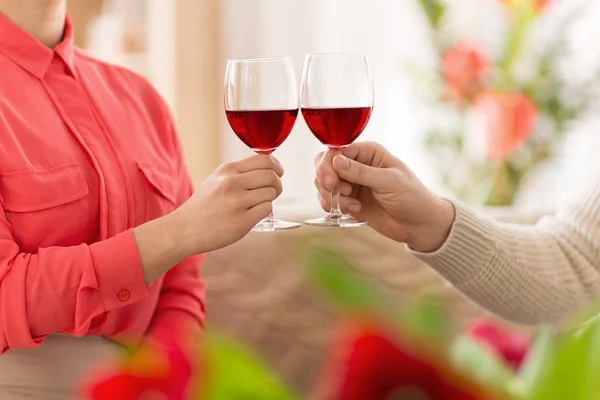 Rukou páru s červeným vínem brýlemi opékání — Stock fotografie