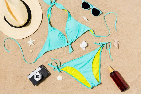 Bikini, chapeau, caméra et lunettes de soleil sur sable de plage — Photo