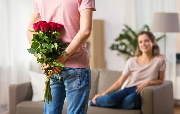 Žena a muž s Kytice růží za jeho zády — Stock fotografie
