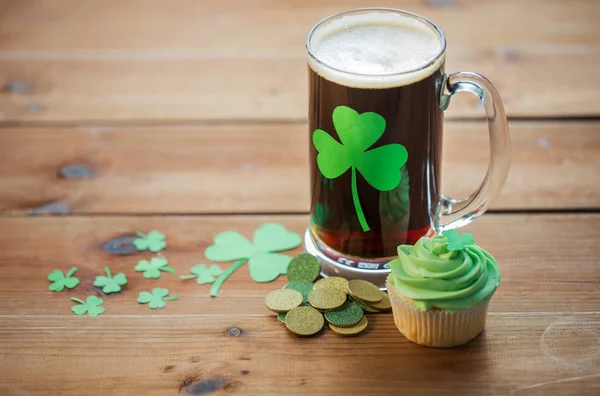 Shamrock op glas bier, groene cupcake en munten — Stockfoto