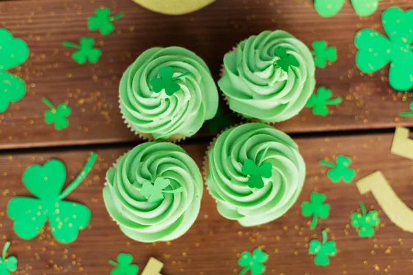 Green cupcakes and shamrock on wooden table — Stock Photo, Image