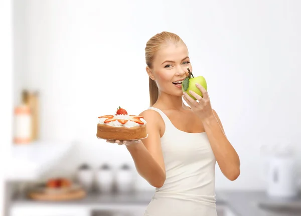 Mulher feliz comendo maçã em vez de bolo — Fotografia de Stock