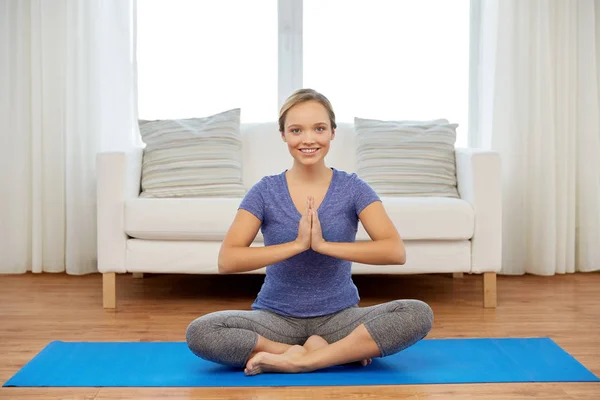 Woman meditating in lotus pose at home — Stock Photo, Image