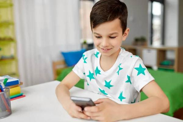 Menino feliz com smartphone em casa — Fotografia de Stock