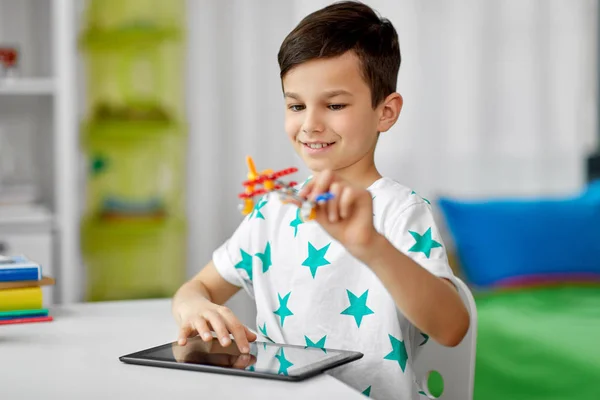 Junge mit Tablet-Computer und Spielzeugflugzeug zu Hause — Stockfoto