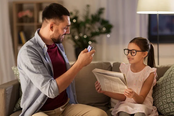 Far fotografering dotter av mobiltelefon hemma — Stockfoto