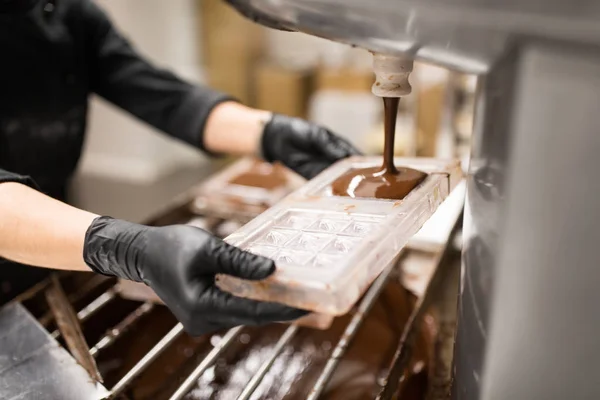 Confitero hace dulces de chocolate en la tienda de dulces —  Fotos de Stock