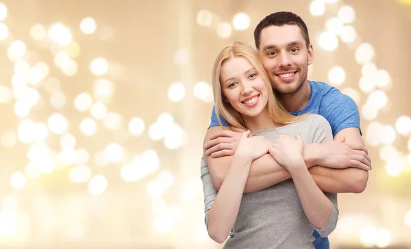 Sorrindo casal abraçando luzes festivas — Fotografia de Stock