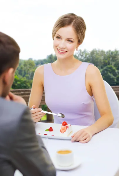 Vrouw op zoek naar man en taart eten in restaurant — Stockfoto