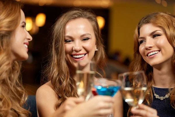 Happy women clinking glasses at night club — Stock Photo, Image