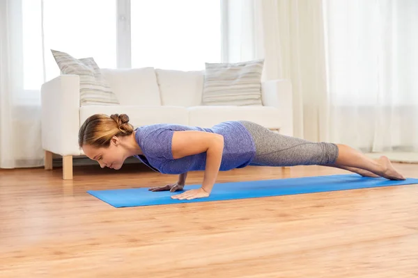 Mujer haciendo yoga cuatro extremidades palo pose en casa — Foto de Stock