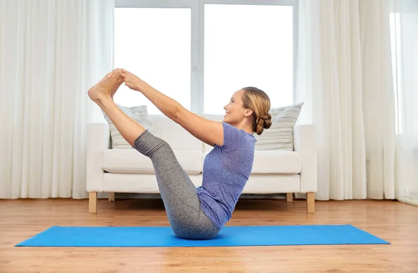 Mulher fazendo ioga dedo do pé duplo segurar pose em casa — Fotografia de Stock