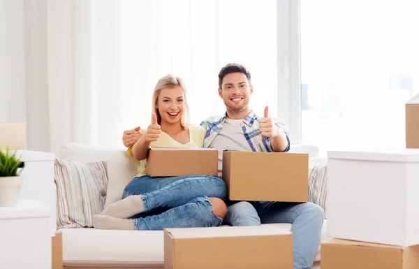 Ευτυχισμένο ζευγάρι με κουτιά που μετακομίζουν σε νέο σπίτι Εικόνα Αρχείου