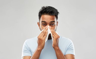 indian man with paper napkin blowing nose clipart