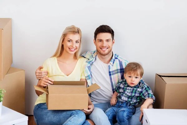 Família feliz com caixas se movendo para nova casa — Fotografia de Stock