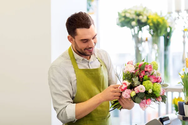 Sorridente florista homem fazendo monte na loja de flores — Fotografia de Stock