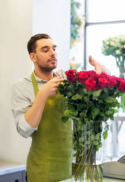 Floristería o vendedor estableciendo rosas rojas en floristería — Foto de Stock