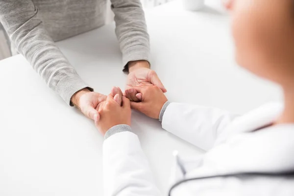 Närbild av läkare håller senior patientens hand — Stockfoto