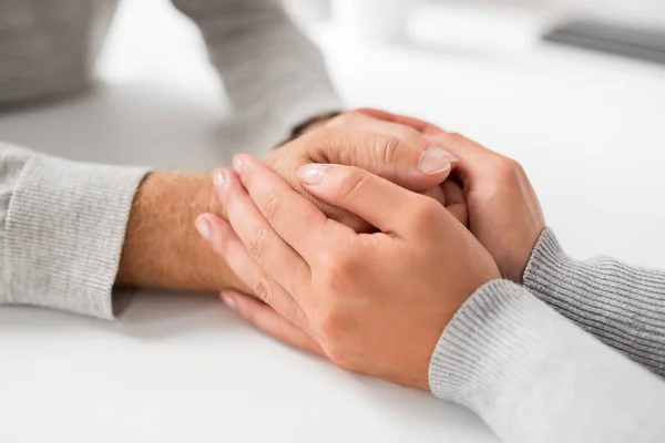 Nahaufnahme einer jungen Frau, die einen älteren Mann an der Hand hält — Stockfoto