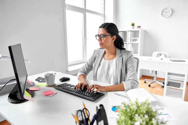 Forretningskvinne med datamaskin som arbeider ved kontoret – stockfoto