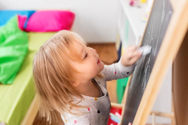 Mutlu küçük kız evde Tebeşir tahtaya çizim — Stok fotoğraf