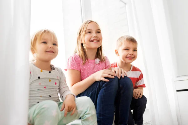 Щасливі маленькі діти сидять на підвіконні — стокове фото
