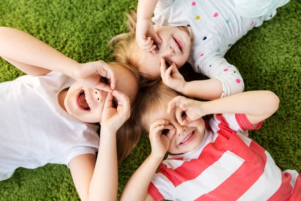 Happy little kids looking through finger glasses — Stock Photo, Image