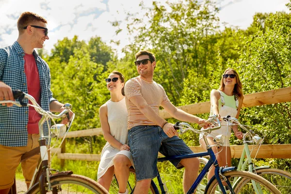 Amici felici a cavallo di biciclette a scatto fisso in estate — Foto Stock