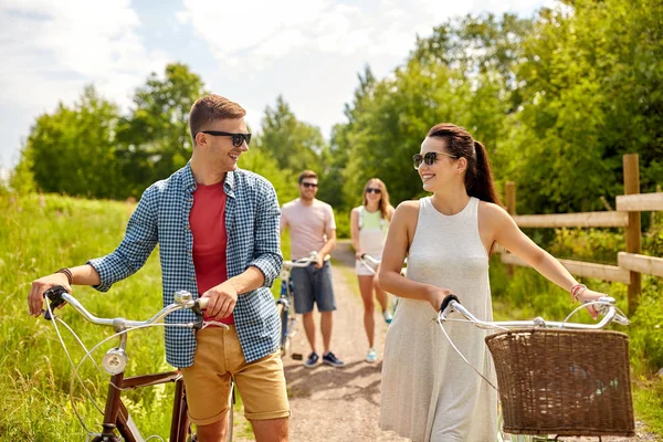 Happy couple with bicycles at summer park — Stock Photo, Image