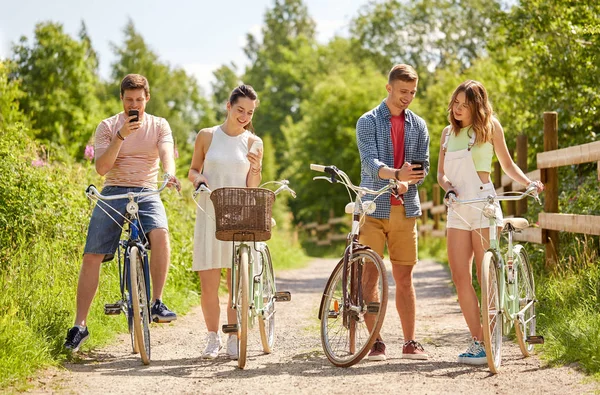 Coppia con biciclette e smartphone in estate — Foto Stock