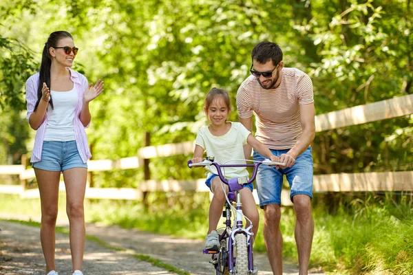 Niño con patentes aprendiendo a andar en bicicleta en el parque —  Fotos de Stock