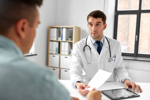 Doctor giving prescription to patient at hospital — Stock Photo, Image