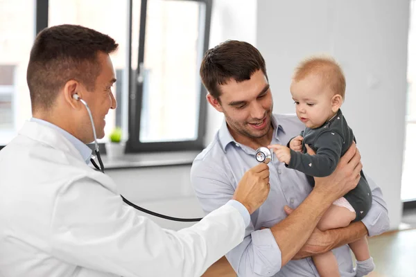 Father with baby and doctor at clinic — Stock Photo, Image