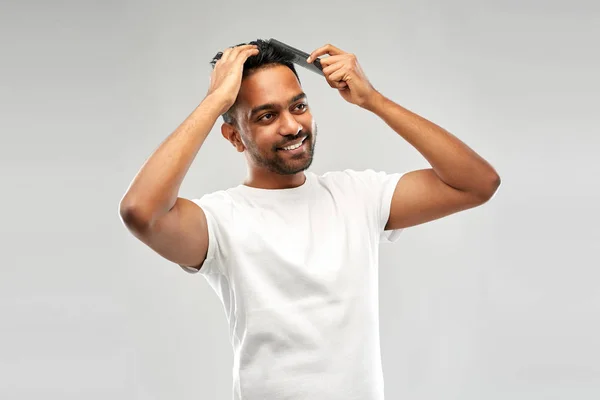 Glücklicher indischer Mann, der Haare mit Kamm bürstet — Stockfoto