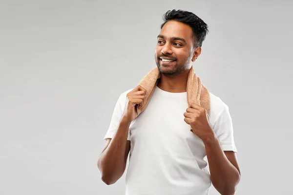 Hombre indio sonriente con toalla sobre fondo gris —  Fotos de Stock