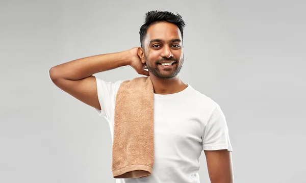 Улыбающийся индиец с полотенцем на сером фоне — стоковое фото